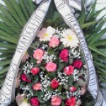 Wieniec z naturalnych kwiatów na podkładzie świerkowym liściach palmowych.Cena od 120 zł.